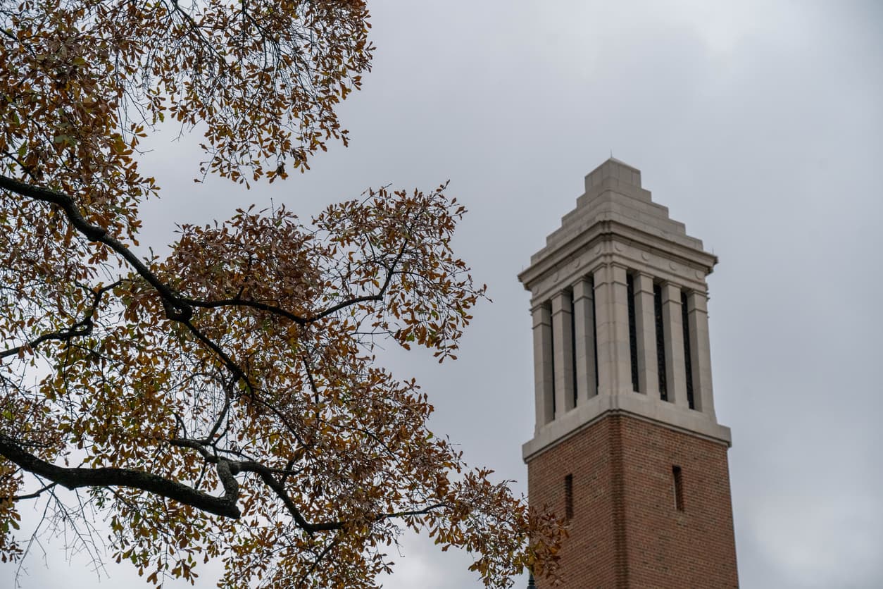 Denny Chimes bell tower at the University of Alabama in Tuscaloosa, framed by autumn oak branches