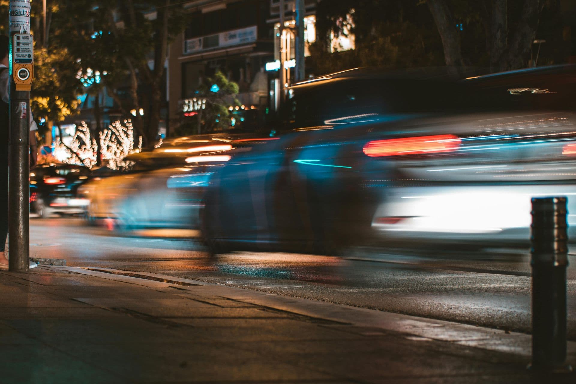 Car headlights streaking through a city street at night